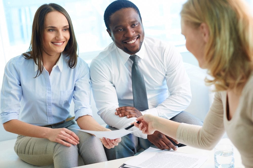 Should I use a financial advisor or do it myself? - man and a woman sitting with a financial advisor