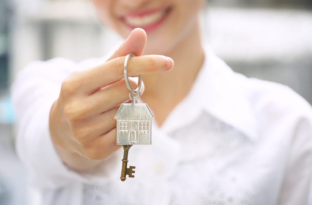 Young woman holding keys to an apartment