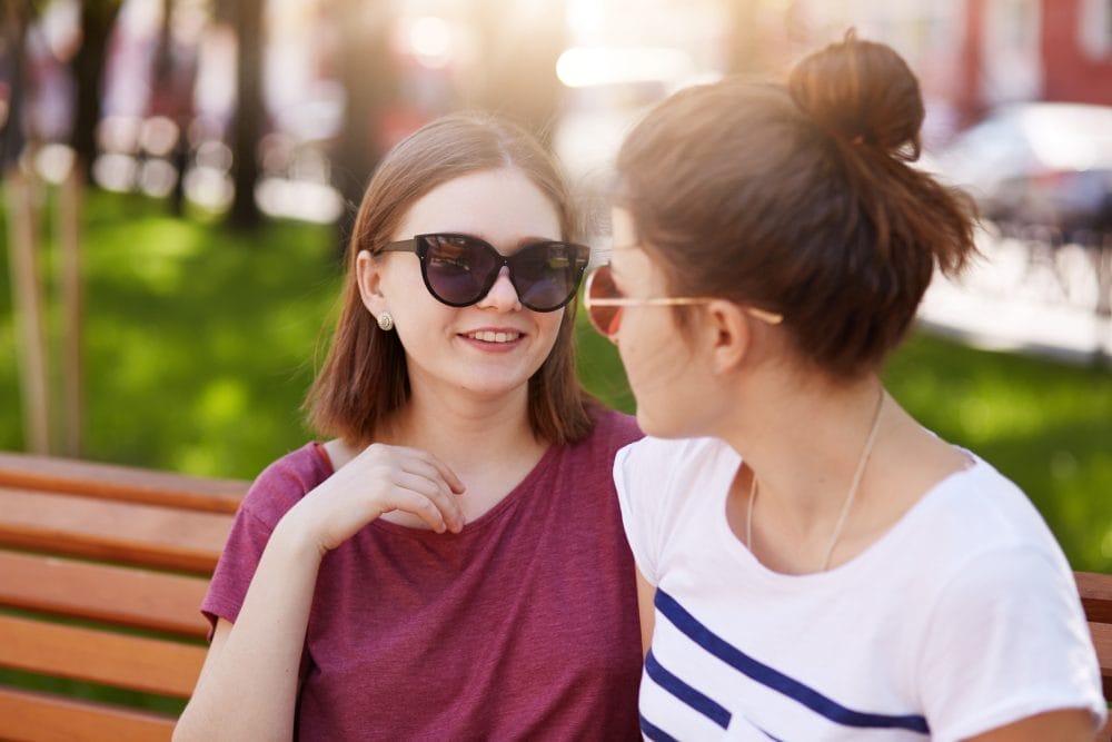 A woman talking to her friend on a bench