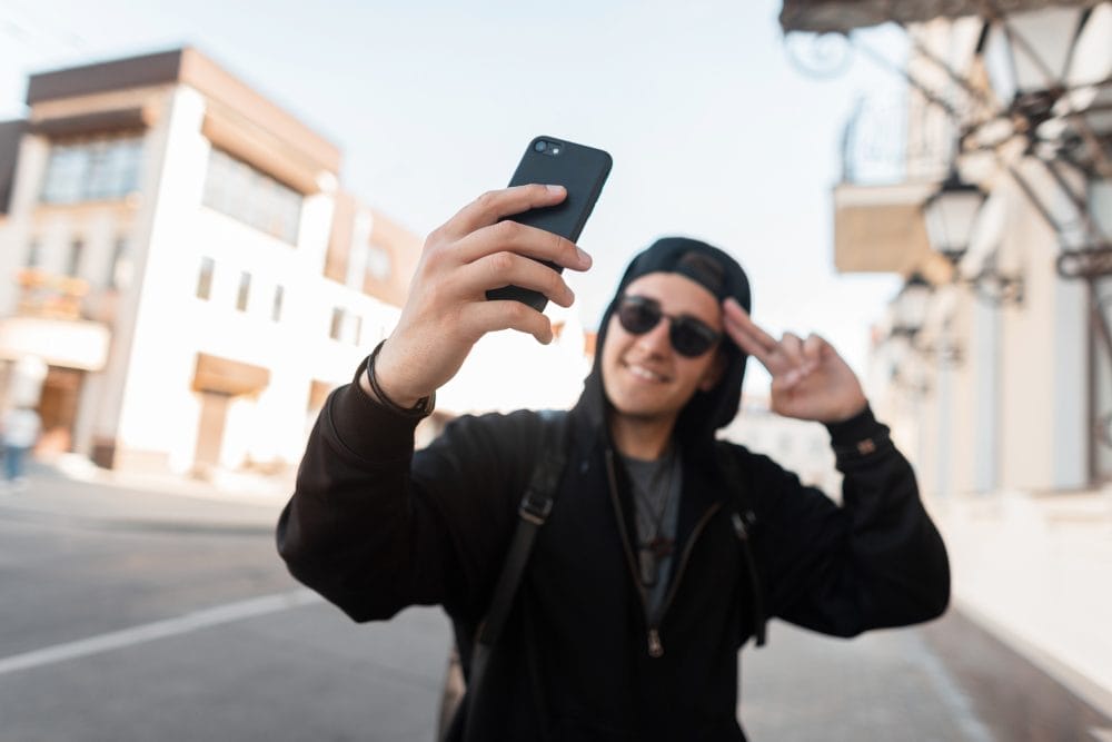 An influencer standing outside and taking a selfie