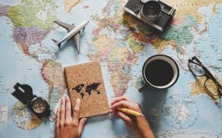 Map of the world with a camera, coffee up, and more on top