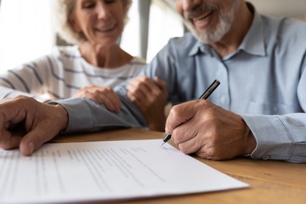 An older couple signing estate planning paperwork