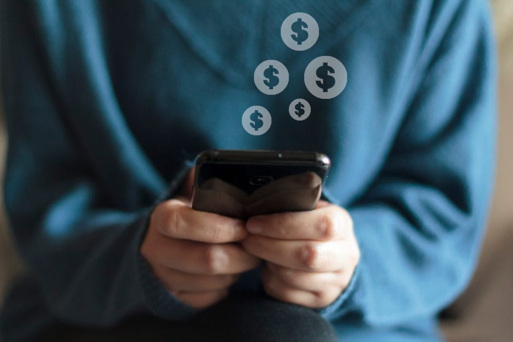 A woman typing money signs on a smartphone