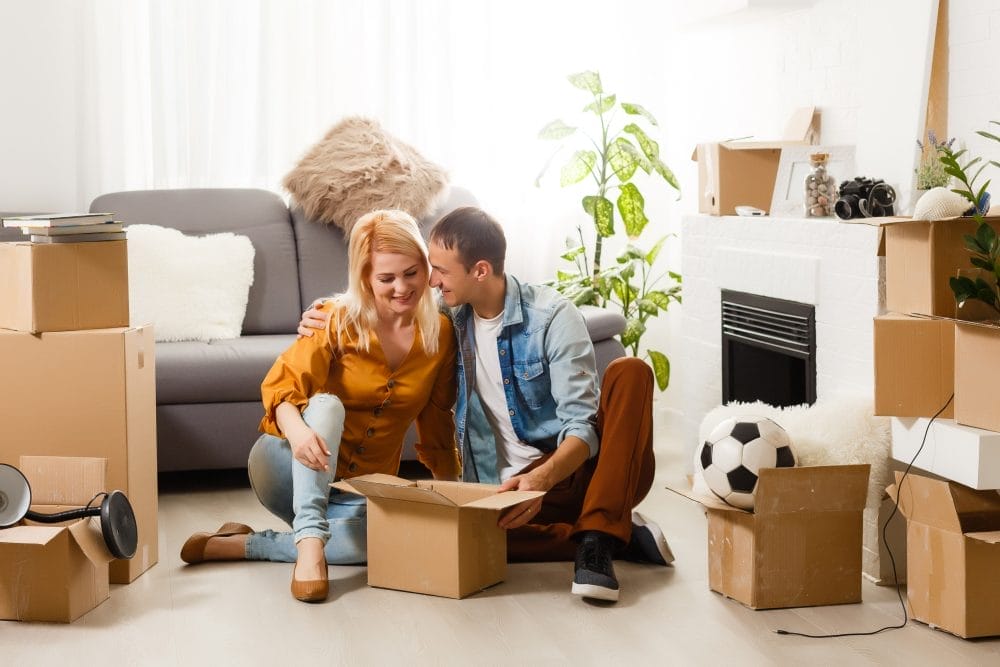 happy couple moving in together with a lot of boxes