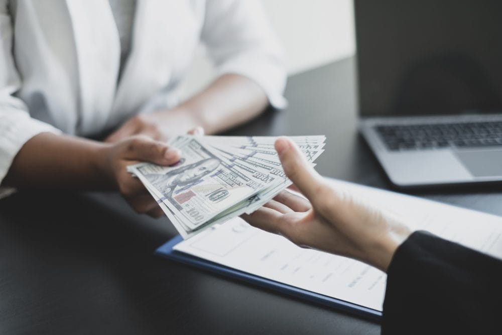 Employee being handed cash across a desk