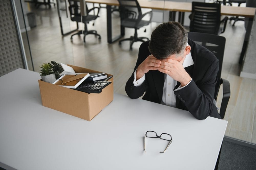 A depressed man at his desk after being fired