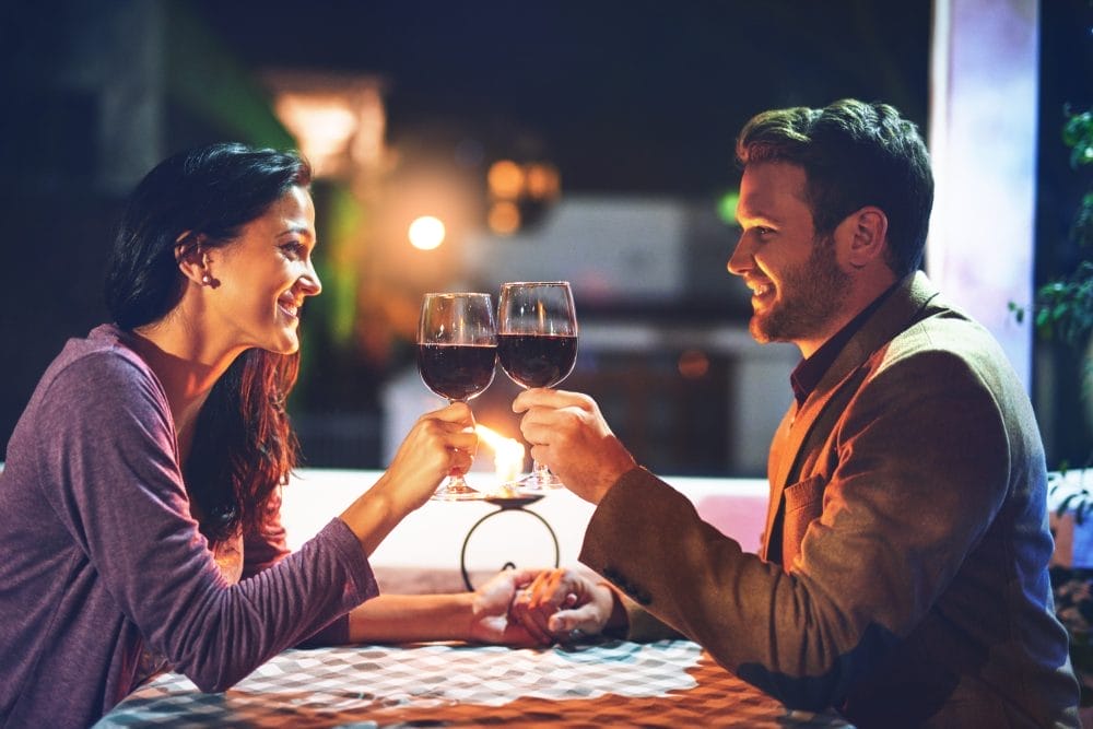 A husband and wife drinking wine on a date