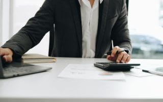 Young male work with financial papers at home count on calculator before paying taxes receipts online, planning budget glad to find chance for economy saving money, audit concepts