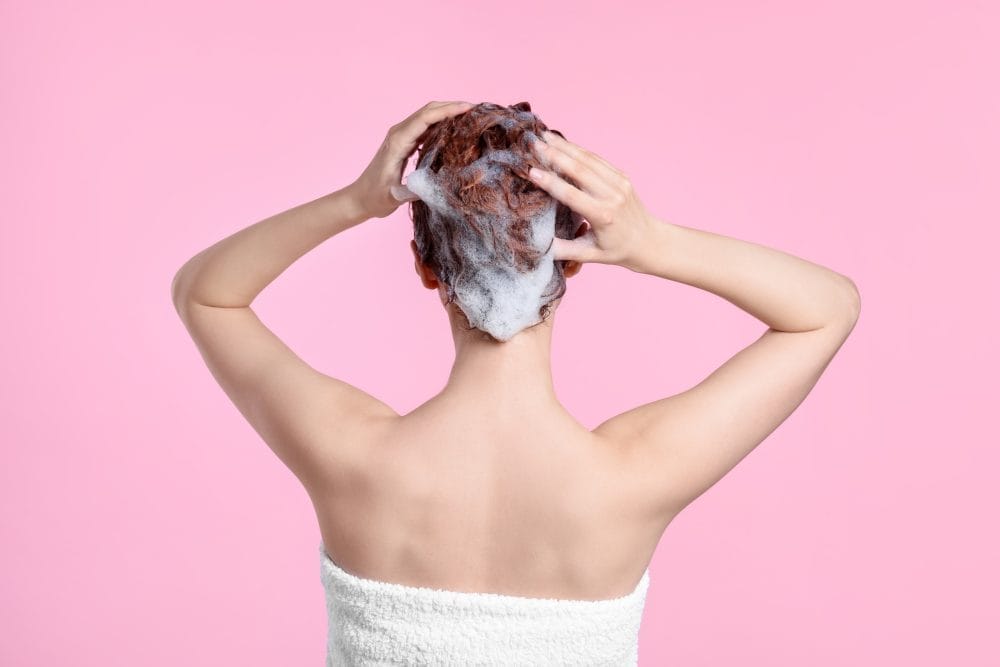 A woman cleaning her hair with shampoo