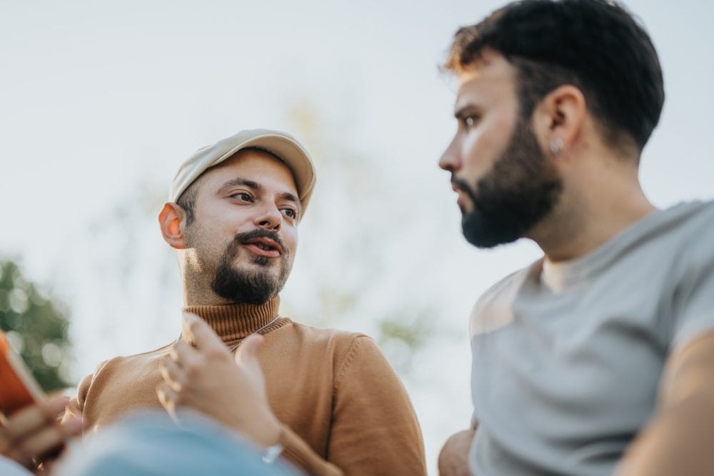 Two men having a thoughtful conversation outdoors under the sunlight