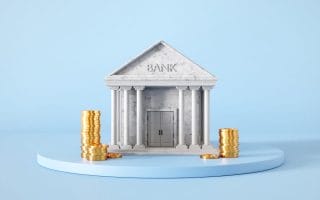 Bank building with golden coins on blue background