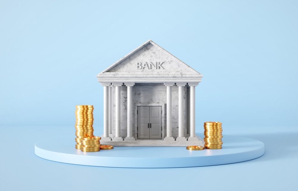 Bank building with golden coins on blue background