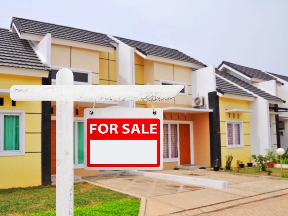 A For Sale sign in front of a house