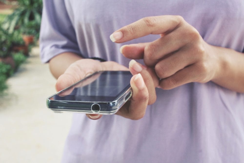 woman's hand scrolling through smartphone