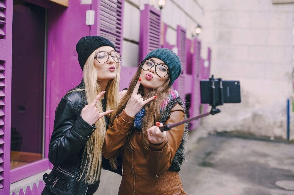 Two female friends taking a photo with a selfie stick