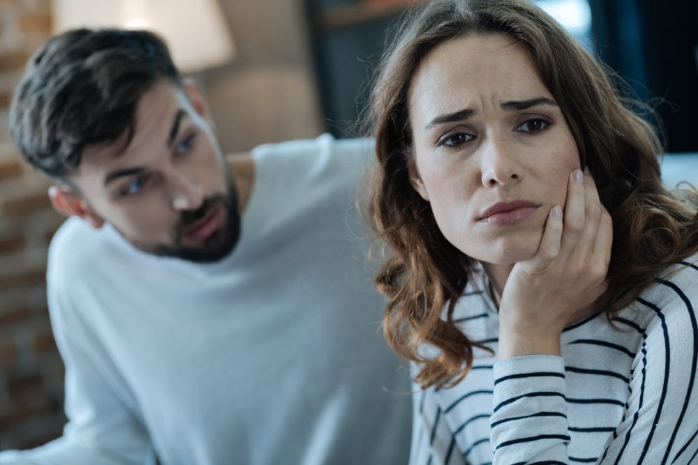 An unhappy woman looking away from her boyfriend