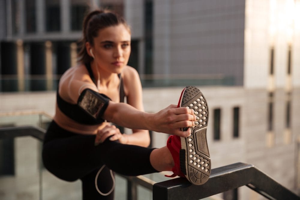 A woman streching her leg prior to working out