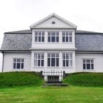 A mansion on a green grassy hill