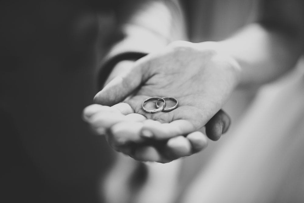 A married couple holding wedding rings