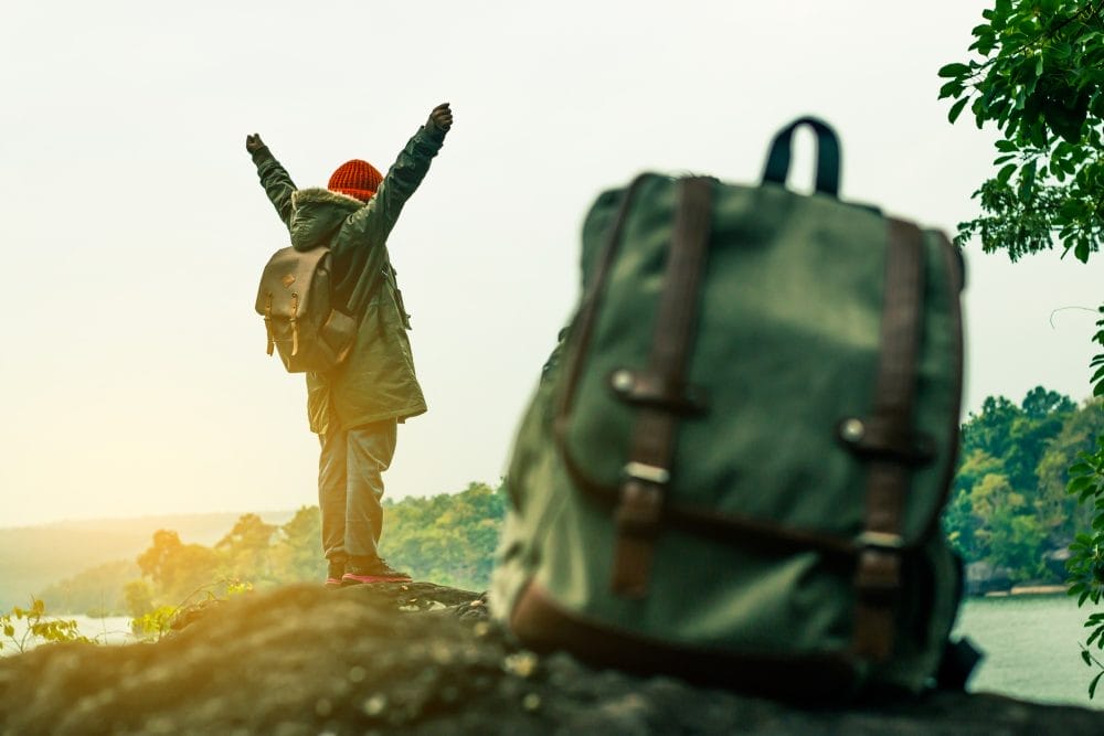 A traveler outdoors with a backpack in the foreground