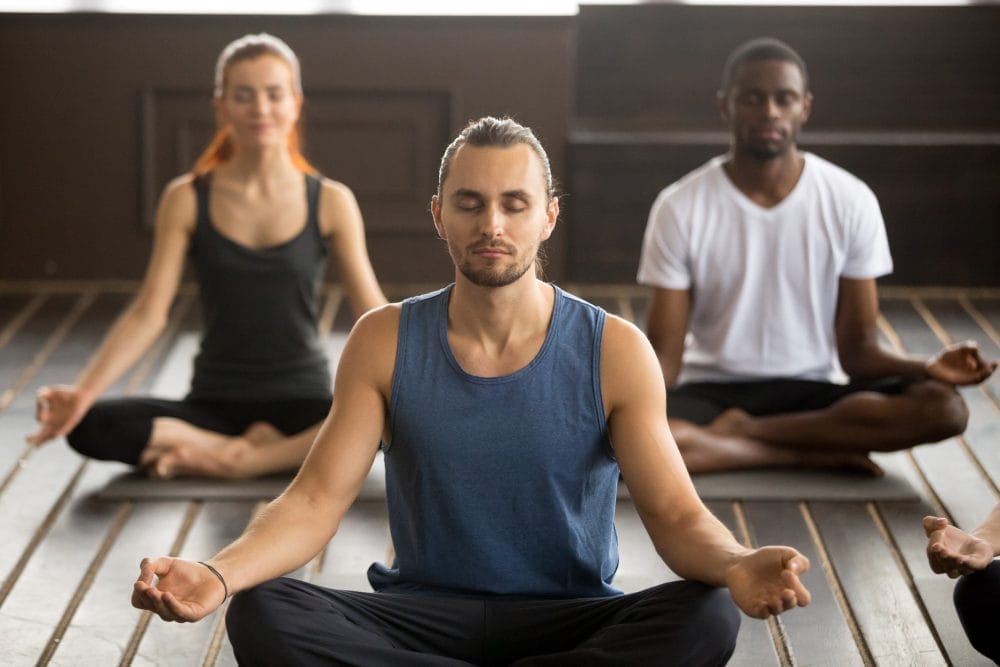 A group of three people meditating together
