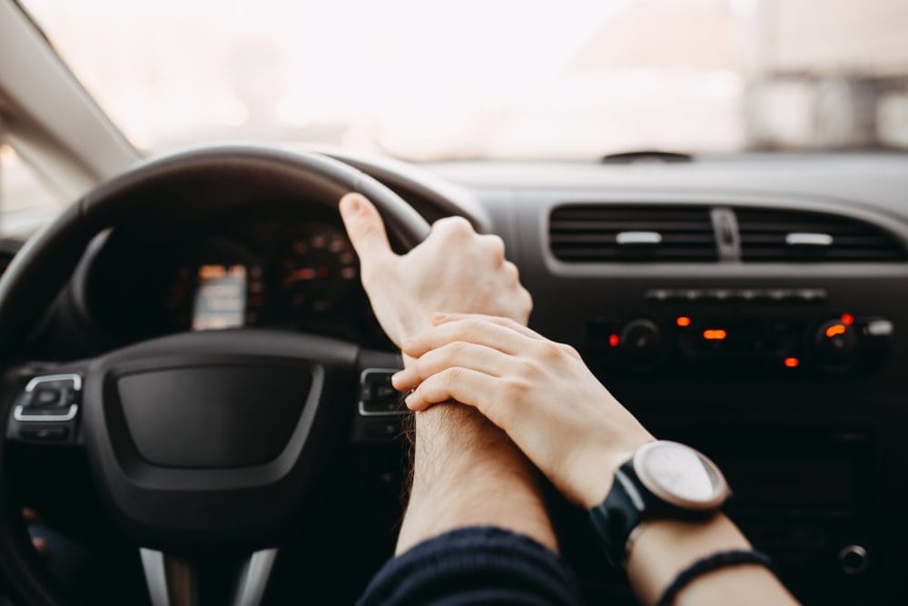A hand on the wrist of a driver