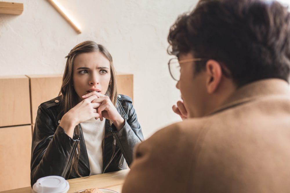 A young woman not looking interested while sitting on a date 