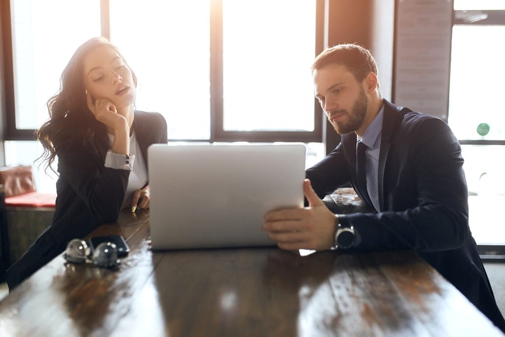 Two employees sharing a laptop