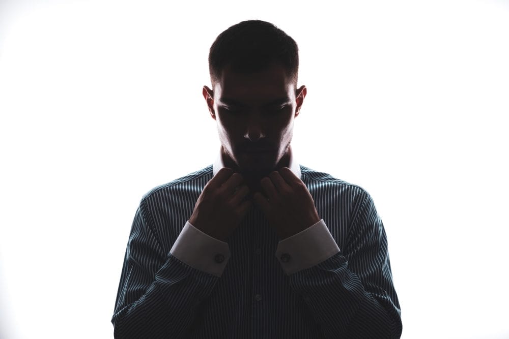 A man alone in the shadows, facing threats and toxic maculinity