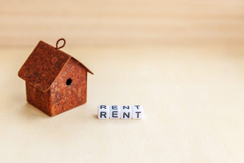 Miniature toy model house with RENT written in blocks