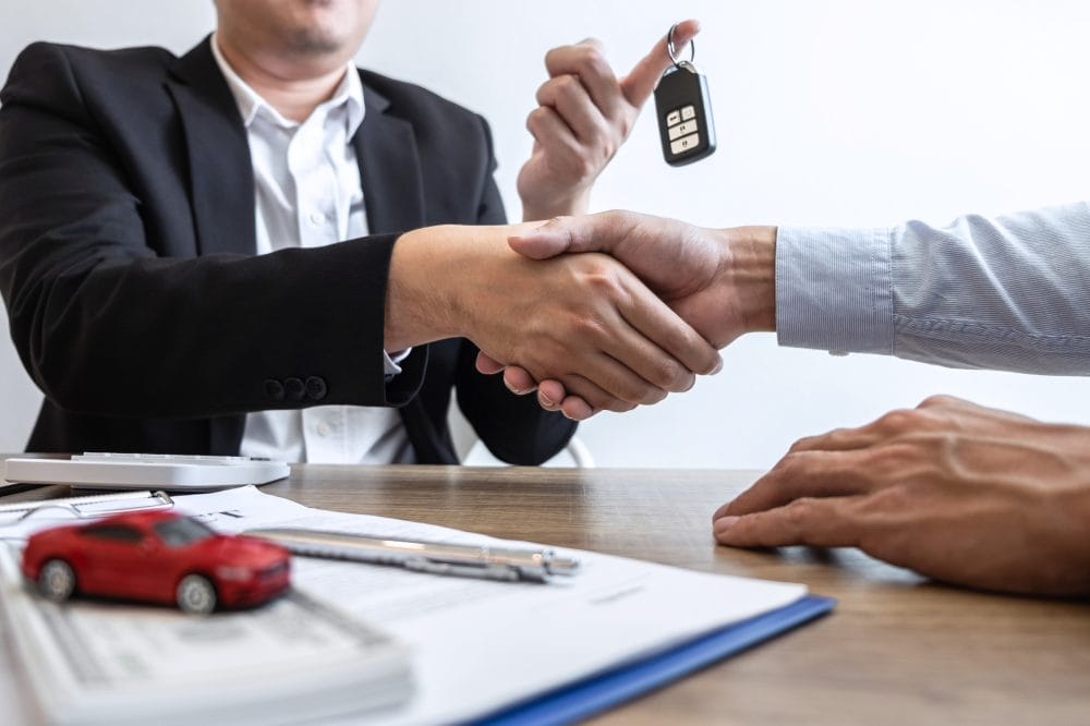 A car dealer handing over car keys