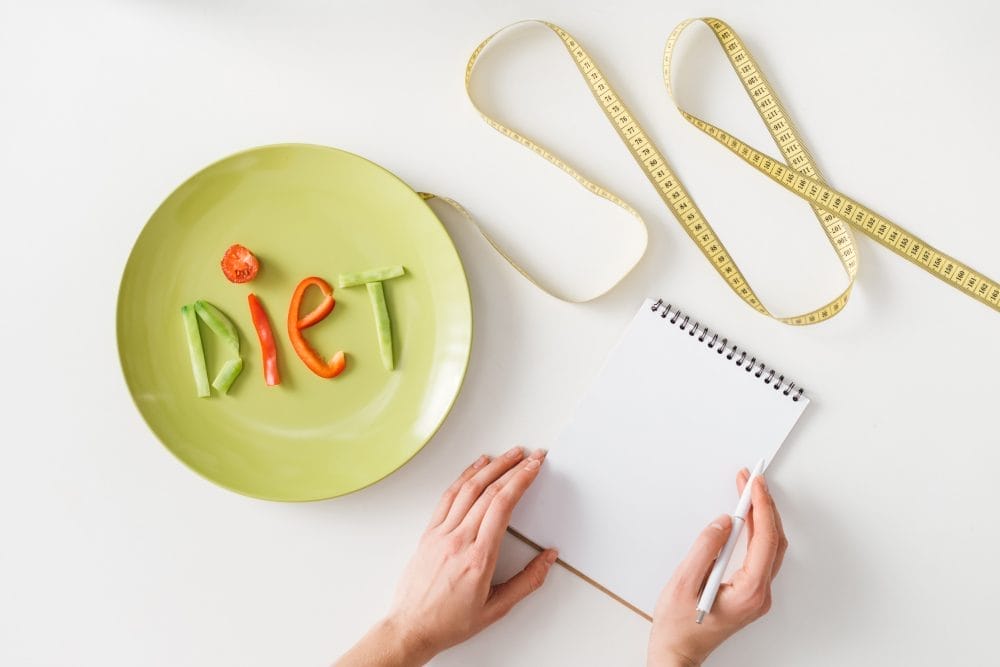 The word "diet" written in vegetables on a plate