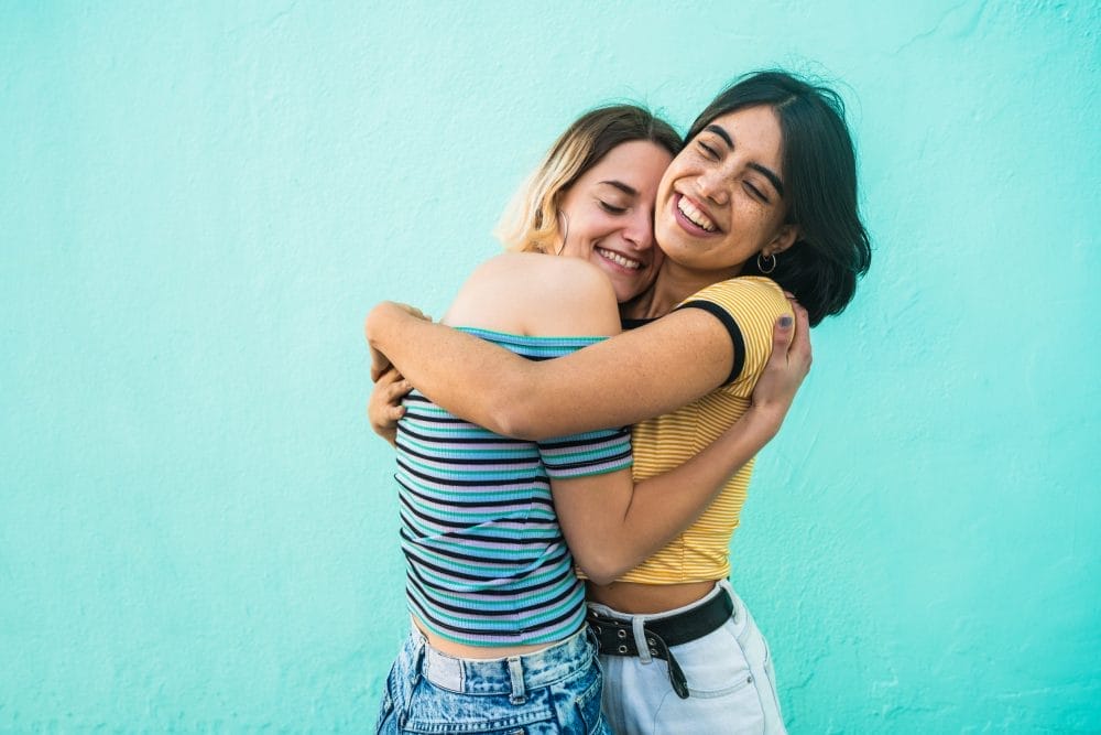 A pair of female friends hugging. Some modern women are cutting off friendships on purpose.