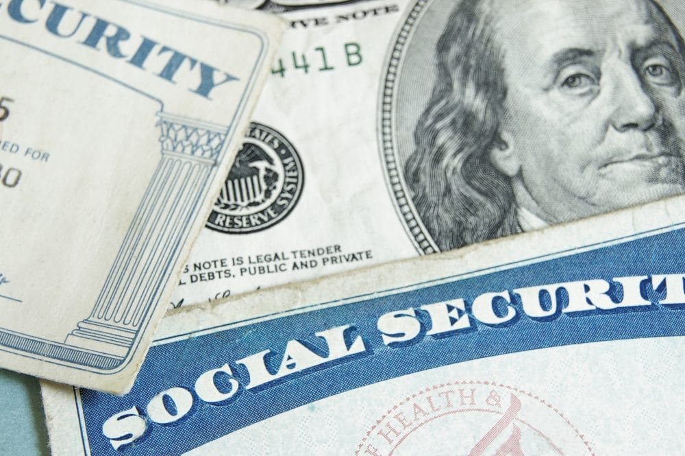 Social security cards on a $100 bill