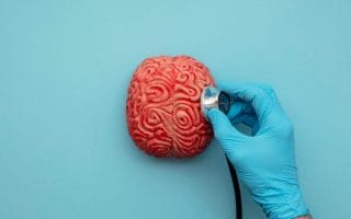 Doctor using a stethoscope to analyse a brain.