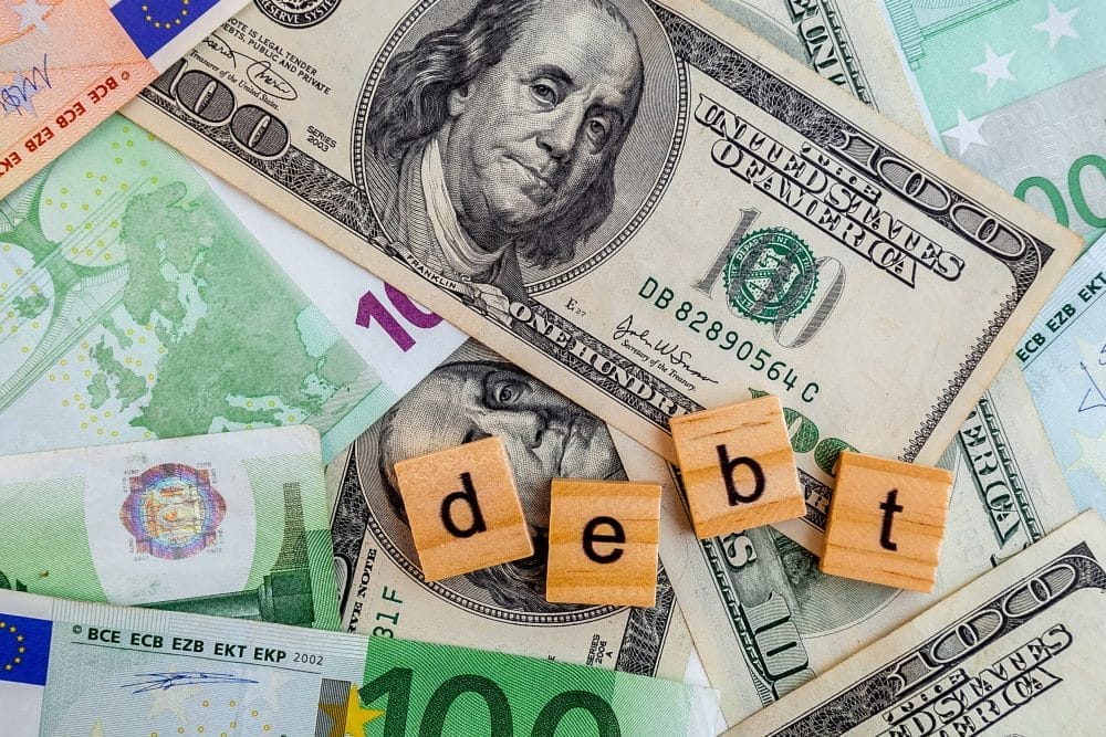 debt inscription on wooden cubes on the US dollars and euro banknotes