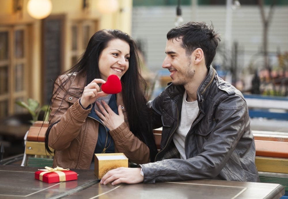 A young couple on a date holding a red heart