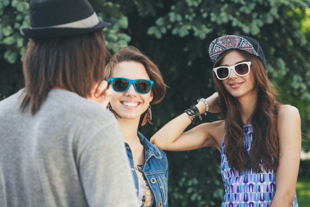 Two young woman communicate with a man