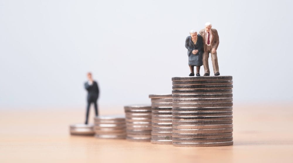 Miniature figures young man thinking and Seniors on a stack of coins