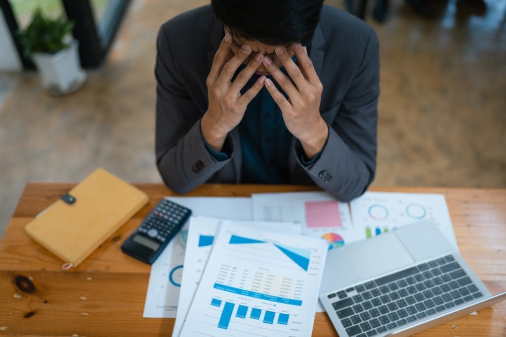 Business owner holding head in his hands