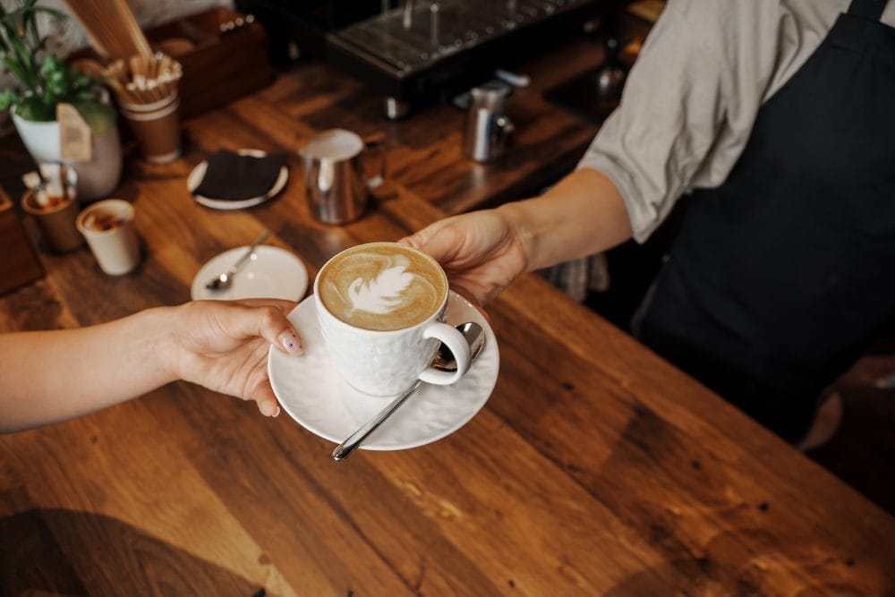 A woman getting an elegant cup of coffee at a coffee shop