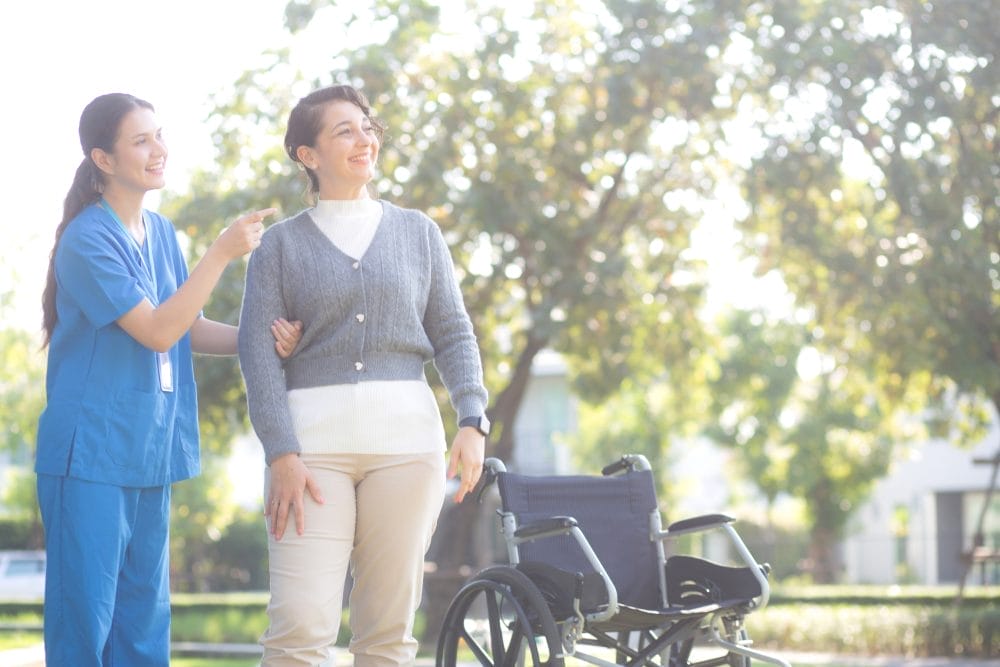 Young caucasian nurse comforting with patient while standing in outdoor park