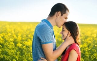 A happy husband kissing his wife on the forehead