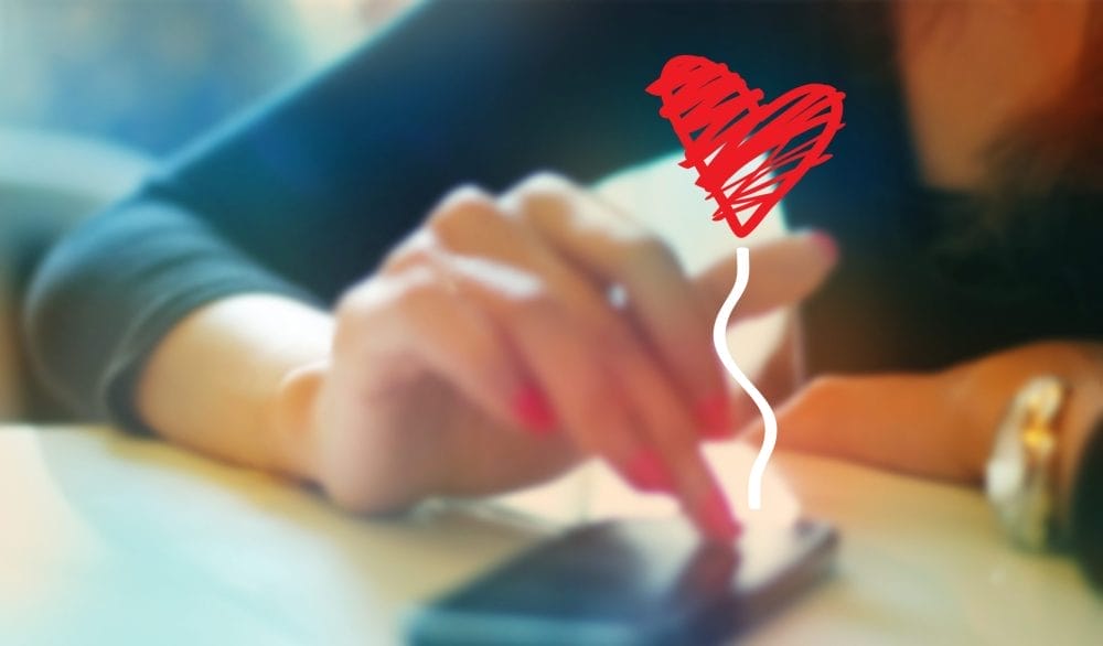 An older woman falling for a romance scam on her smartphone