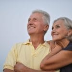 Smiling elderly couple looking out to the sky