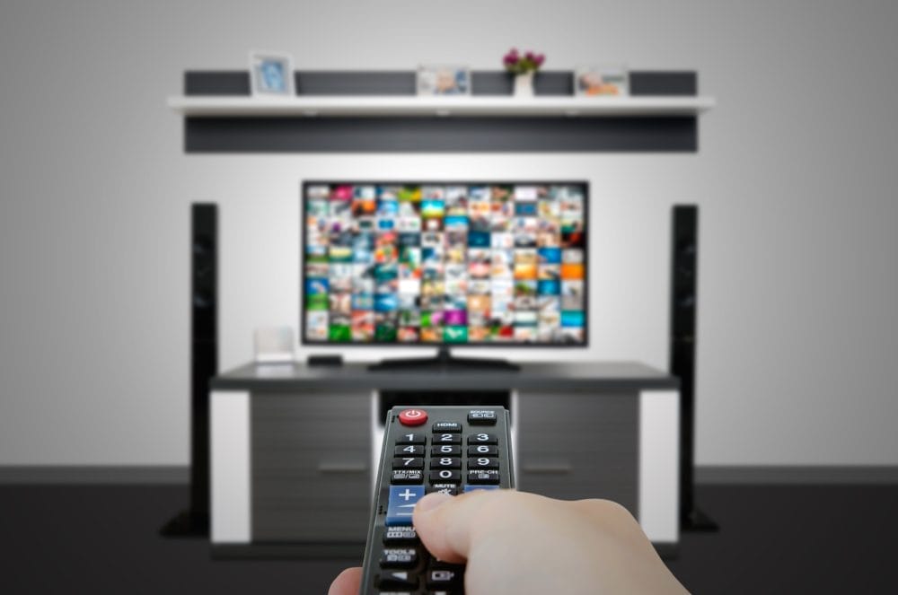 A remote pointed at a television with a lot of content