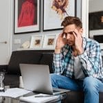 A man frustarted while working at home on his laptop