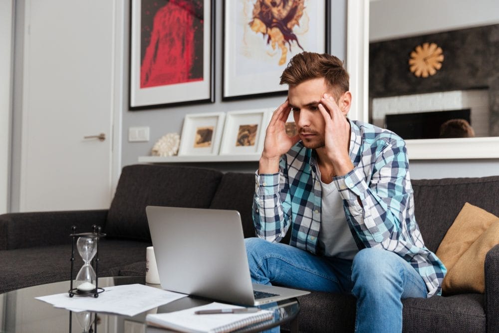 A man frustarted while working at home on his laptop