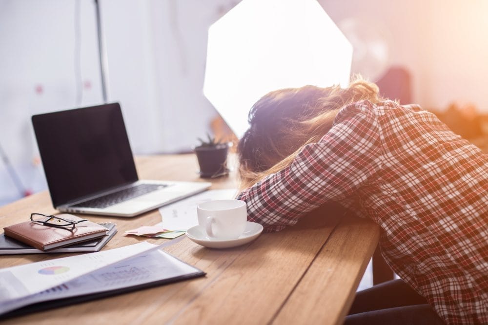 Young businesswoman tired at her work desk