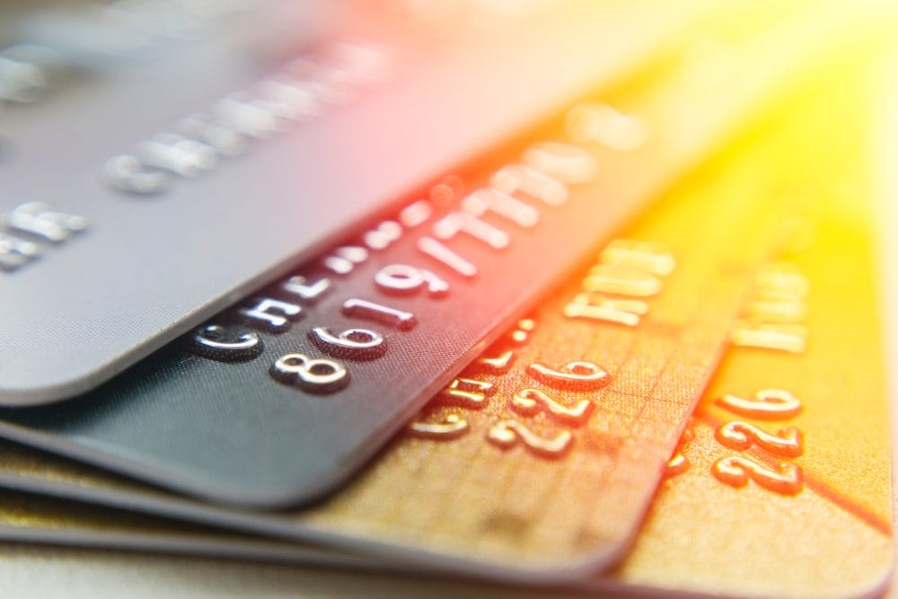 A group of gold and black credit cards and their perks